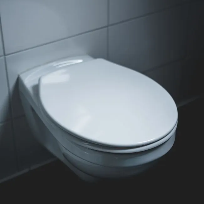 A sleek and modern white toilet in a well-lit minimalist bathroom setting.